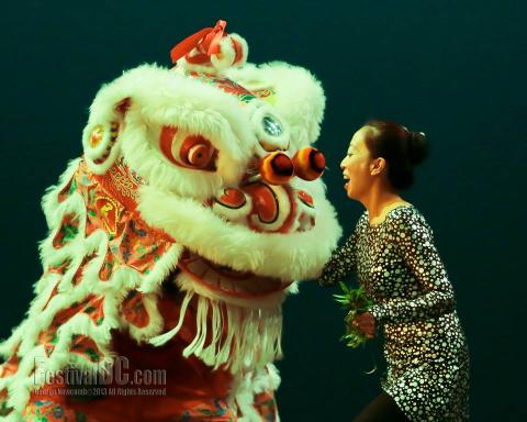 Wu Ping feeds a mischievous lucky lion.